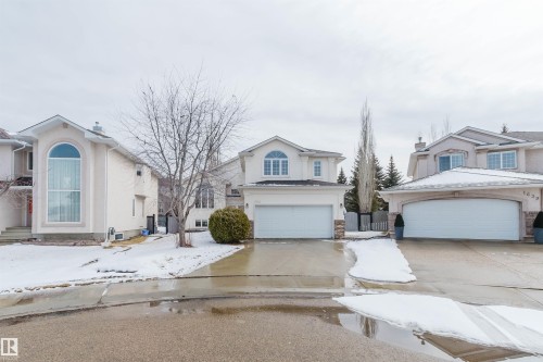 The property features a two-story design, an attached garage, and a paved driveway - 1641 Forbes Way, Edmonton, AB - Outdoor With Facade