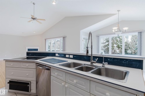 Kitchen area featuring white cabinetry, a double basin stainless steel sink, and an integrated dishwasher - 1641 Forbes Way, Edmonton, AB - Indoor Photo Showing Kitchen With Double Sink