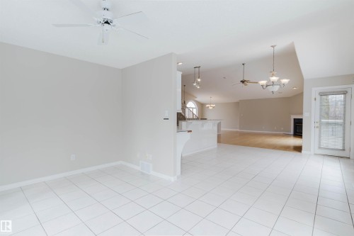 This spacious interior features a combination of white tiled flooring and hardwood flooring - 1641 Forbes Way, Edmonton, AB - Indoor