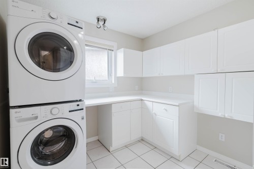 The property features a laundry area with white cabinetry, a countertop, and tiled flooring - 1641 Forbes Way, Edmonton, AB - Indoor Photo Showing Laundry Room