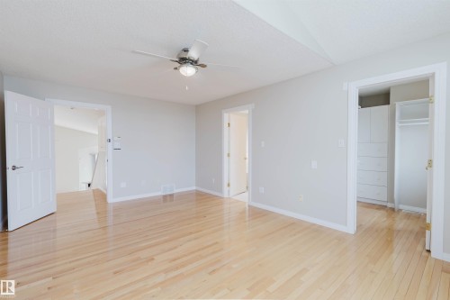 The property features light hardwood floors, light gray walls, and white trim throughout the room - 1641 Forbes Way, Edmonton, AB - Indoor Photo Showing Other Room