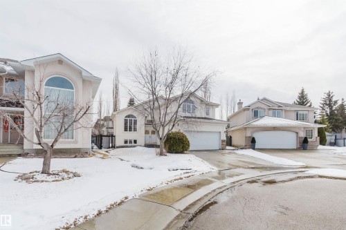 The property features a two-story design with a two-car garage and a paved driveway - 1641 Forbes Way, Edmonton, AB - Outdoor With Facade