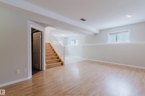 The interior features light wood floors and light grey walls - 1641 Forbes Way, Edmonton, AB - Indoor Photo Showing Other Room
