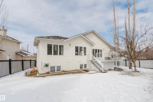 The property features a rear deck with white railings and glass panels, accessible via a staircase - 1641 Forbes Way, Edmonton, AB - Outdoor
