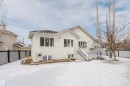 The property features a rear deck with white railings and glass panels, accessible via a staircase - 1641 Forbes Way, Edmonton, AB  - Outdoor 