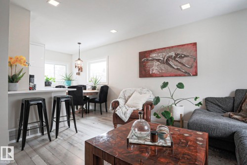 Open-concept living space featuring light-toned flooring, recessed lighting, and large windows providing natural light - 9319 92 Street, Edmonton, AB - Indoor Photo Showing Living Room