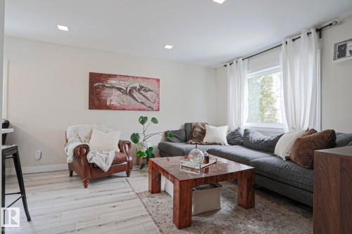 Living area featuring light-colored flooring, a window providing natural light, and recessed lighting - 9319 92 Street, Edmonton, AB - Indoor Photo Showing Living Room