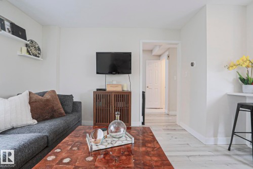The living area features light-colored walls and flooring, with a hallway leading to other areas of the property - 9319 92 Street, Edmonton, AB - Indoor
