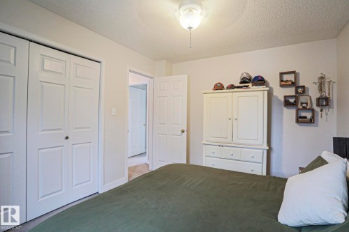 This room features white bi-fold closet doors, a neutral wall color, and a ceiling light fixture - 9319 92 Street, Edmonton, AB - Indoor Photo Showing Bedroom