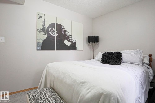 This room features light-colored walls and a textured ceiling - 9319 92 Street, Edmonton, AB - Indoor Photo Showing Bedroom