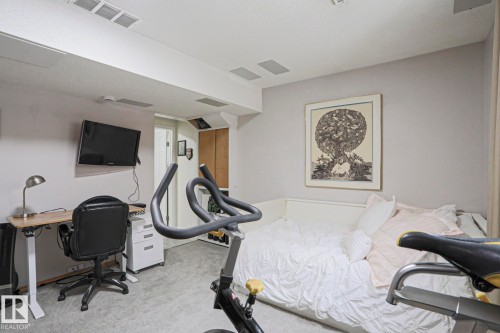 This versatile room features light gray walls, recessed lighting, and gray carpeting - 9319 92 Street, Edmonton, AB - Indoor Photo Showing Bedroom