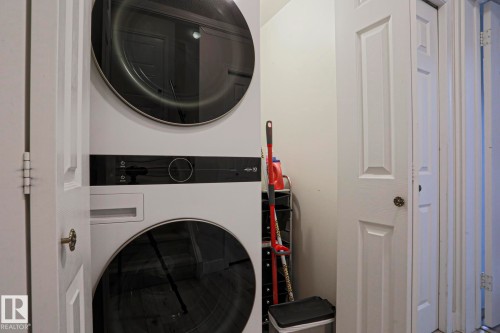 Convenient in-unit laundry area featuring a stacked washer and dryer set - 9319 92 Street, Edmonton, AB - Indoor Photo Showing Laundry Room