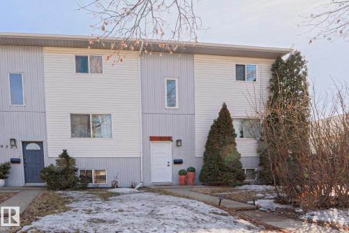 This property features a multi-level exterior with a light-colored siding and a dark lower section, accented by various windows - 9319 92 Street, Edmonton, AB - Outdoor