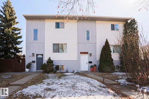 The property features a two-story exterior with light-colored siding, a flat roof, and multiple windows - 9319 92 Street, Edmonton, AB - Outdoor