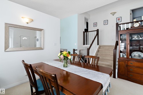 The dining area features a hardwood table and carpeted flooring - 322 Pearson Crescent, Edmonton, AB - Indoor Photo Showing Dining Room
