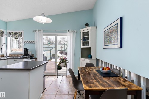 The dining area features a wooden table and a corner cabinet with a glass front - 322 Pearson Crescent, Edmonton, AB - Indoor Photo Showing Dining Room