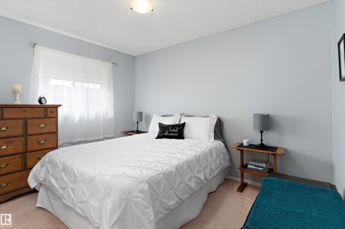 This room features light blue walls, a window with sheer white curtains, and a white ceiling light fixture - 322 Pearson Crescent, Edmonton, AB - Indoor Photo Showing Bedroom