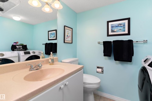 The property features a bathroom with a vanity, mirror, and light fixture, complemented by light blue walls - 322 Pearson Crescent, Edmonton, AB - Indoor Photo Showing Bathroom