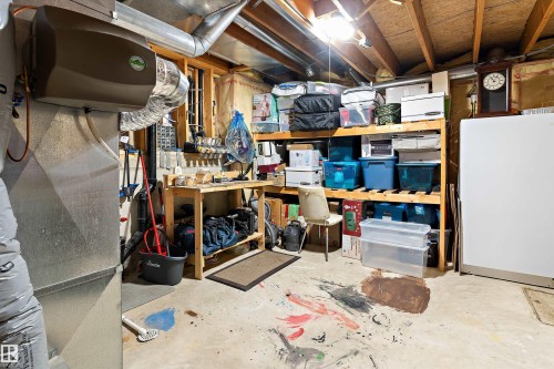 The property features a utility area with exposed ceiling joists and ductwork, illuminated by an overhead light - 322 Pearson Crescent, Edmonton, AB - Indoor Photo Showing Basement