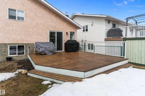 The property features a spacious wooden deck with white railing, accessible via a sliding glass door, providing an inviting outdoor area - 322 Pearson Crescent, Edmonton, AB - Outdoor With Exterior