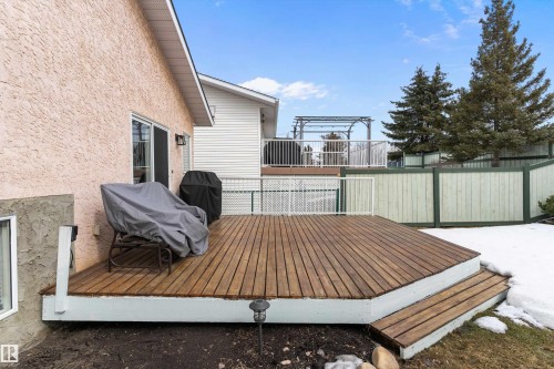 The property features a wooden deck with steps, a sliding glass door, and a light-colored stucco exterior - 322 Pearson Crescent, Edmonton, AB - Outdoor With Deck Patio Veranda With Exterior