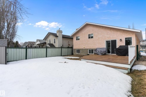 The property features an outdoor deck with white railings, a sliding glass door leading into the property, and a textured exterior finish - 322 Pearson Crescent, Edmonton, AB - Outdoor