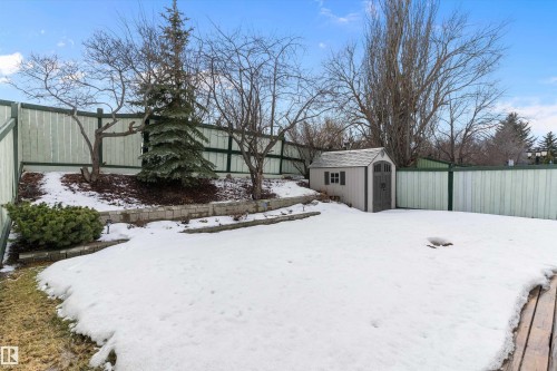 The property features a fenced yard with a small shed, mature trees, and a retaining wall - 322 Pearson Crescent, Edmonton, AB - Outdoor