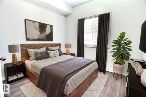Bedroom featuring white walls and wood flooring. Virtually Staged - 209 10235 112 Street, Edmonton, AB - Indoor Photo Showing Bedroom