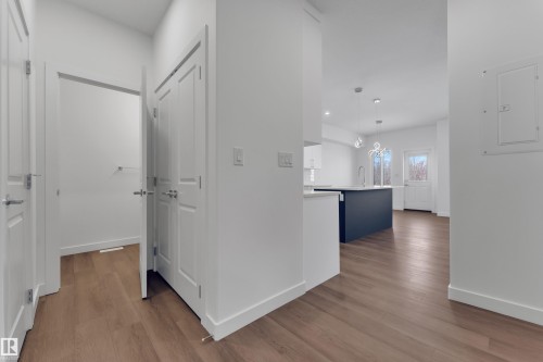 This property features light-toned wood flooring and white walls throughout - 114 Mitchell Bend, Leduc, AB - Indoor Photo Showing Other Room