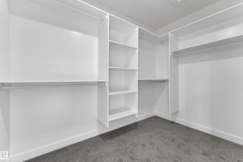 The property features a spacious closet with white shelving and hanging rods, providing ample storage - 114 Mitchell Bend, Leduc, AB - Indoor With Storage