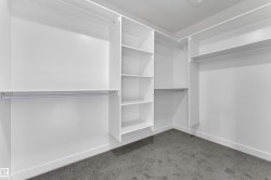 The property features a spacious closet with white shelving and hanging rods, providing ample storage - 