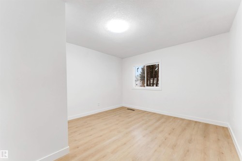 Bright room featuring light-toned flooring, white walls, and a window providing natural light - 12423 91 Street, Edmonton, AB - Indoor Photo Showing Other Room