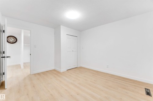 This room features light-toned flooring, white walls, and a closet with bifold doors - 12423 91 Street, Edmonton, AB - Indoor Photo Showing Other Room
