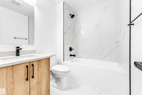 The bathroom features a modern vanity with a light wood finish and a white countertop - 12423 91 Street, Edmonton, AB - Indoor Photo Showing Bathroom