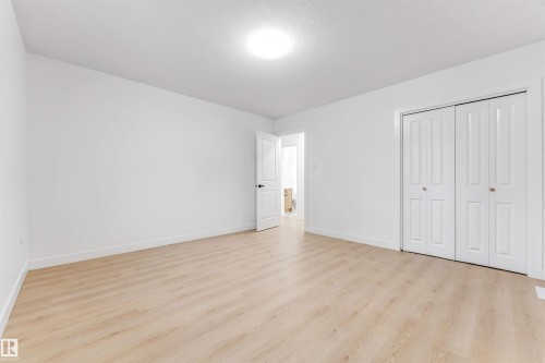 Spacious room featuring light-colored flooring, white walls, and a ceiling light fixture - 12423 91 Street, Edmonton, AB - Indoor Photo Showing Other Room
