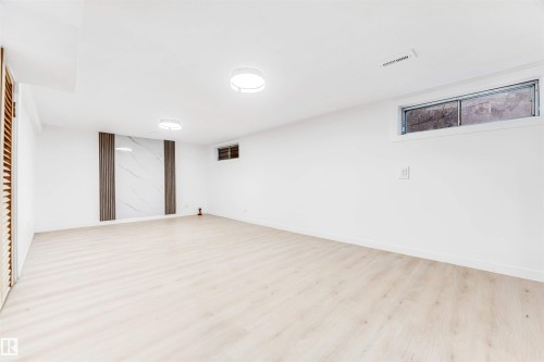 This versatile room features light-toned flooring and white walls, creating a bright and open atmosphere - 12423 91 Street, Edmonton, AB - Indoor Photo Showing Other Room