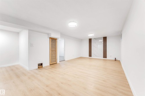 The property features light-toned flooring throughout the room, creating an expansive feel - 12423 91 Street, Edmonton, AB - Indoor Photo Showing Other Room