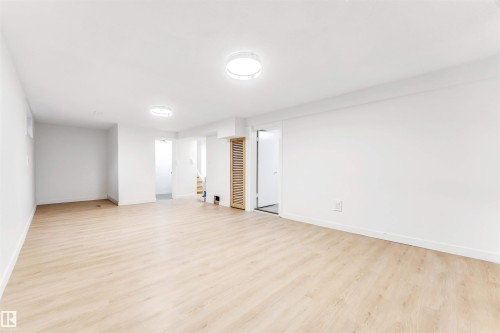 Spacious room featuring light wood-style flooring, white walls, and recessed lighting - 12423 91 Street, Edmonton, AB - Indoor Photo Showing Other Room