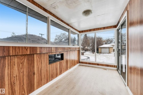 The property features a sunroom with extensive windows, wood paneling, and a light-colored floor - 12423 91 Street, Edmonton, AB -  With Exterior