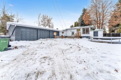 The property features a detached garage with two garage doors and a white exterior on the main residence - 12423 91 Street, Edmonton, AB - Outdoor