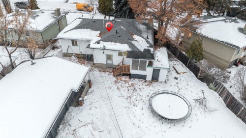The property features a white exterior, a dark shingled roof, and a wood deck - 12423 91 Street, Edmonton, AB - Outdoor