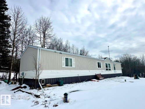 The property features a siding exterior with a white and gray color scheme, set against a backdrop of trees - 50124 Range Road 203, Rural Beaver County, AB - Outdoor