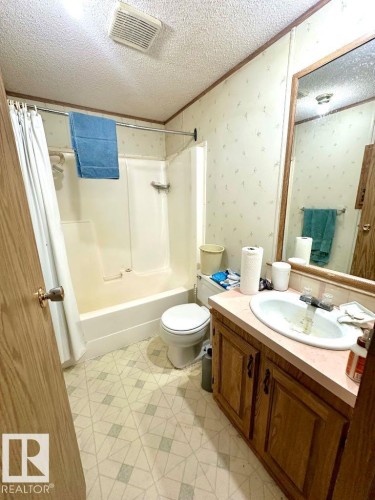 The bathroom features a bathtub and shower combination, a toilet, and a vanity with a sink and storage cabinetry - 50124 Range Road 203, Rural Beaver County, AB - Indoor Photo Showing Bathroom