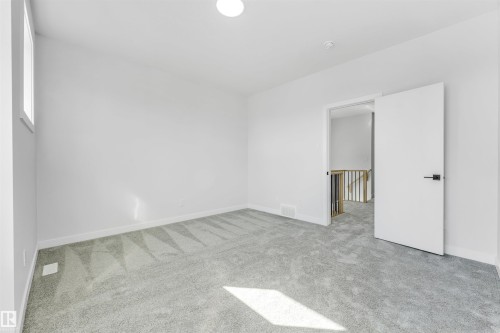 This room features light gray carpeting, white walls, and a window providing natural light - 10962 157 Street, Edmonton, AB - Indoor Photo Showing Other Room