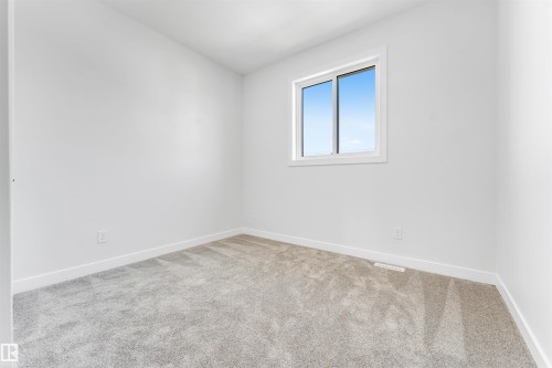 This room features light grey carpeting, white walls, and a window providing natural light - 10962 157 Street, Edmonton, AB - Indoor Photo Showing Other Room