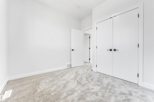 This room features a soft, grey carpet and clean white walls, creating a neutral canvas - 10962 157 Street, Edmonton, AB - Indoor Photo Showing Other Room