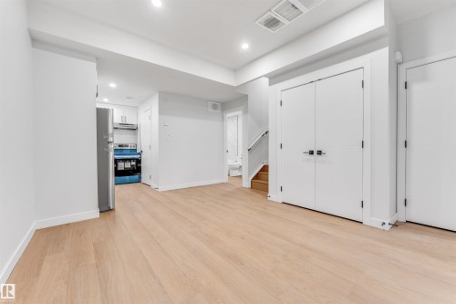 This open-concept living area features light wood flooring, recessed lighting, and white walls - 10962 157 Street, Edmonton, AB - Indoor Photo Showing Other Room