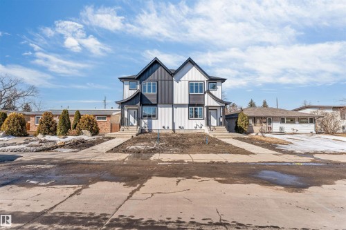 The property features a modern exterior with a prominent A-frame roofline and a combination of dark and light-colored vertical siding - 10962 157 Street, Edmonton, AB - Outdoor