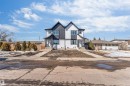 The property features a modern exterior with a prominent A-frame roofline and a combination of dark and light-colored vertical siding - 10962 157 Street, Edmonton, AB  - Outdoor 