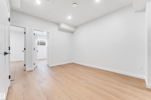 This bright room features light-toned hardwood flooring, white walls, and recessed lighting - 10962 157 Street, Edmonton, AB - Indoor Photo Showing Other Room